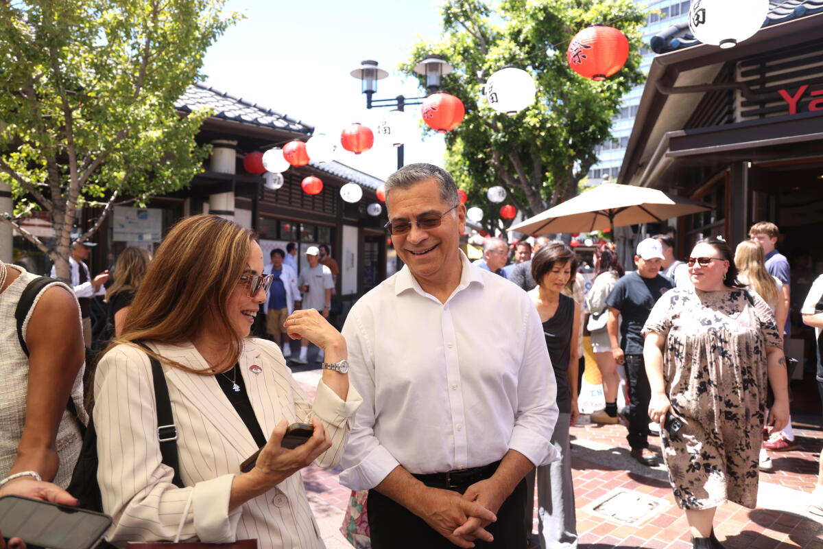 Second. Xavier Becerra (center), who is running for California governor, walks with Helen Horta.