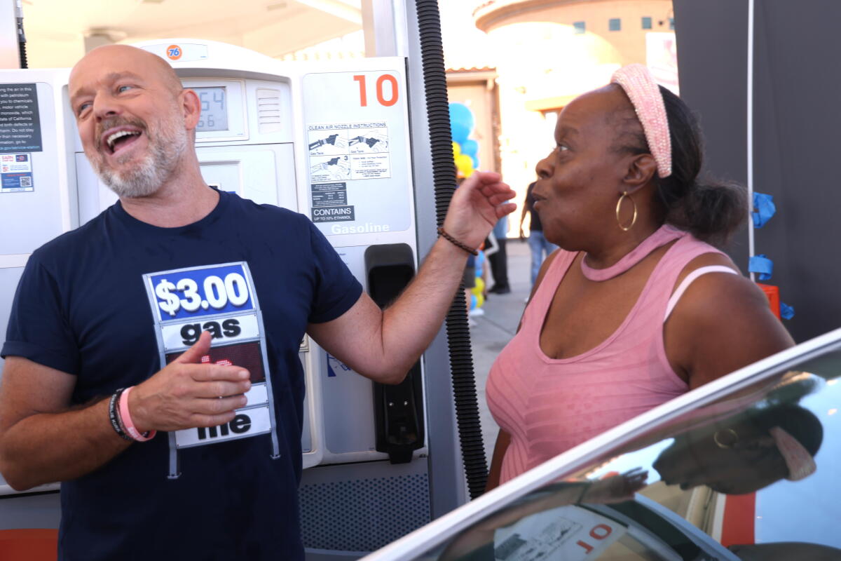 Republican gubernatorial candidate Steve Hilton enjoys a relaxing moment with a woman who is happy to get gas for $3 a gallon