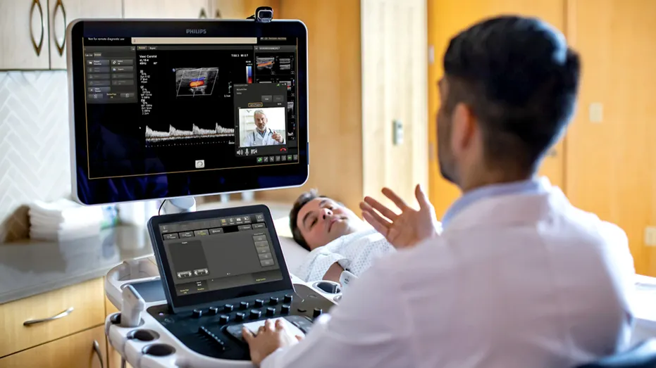 Two doctors use Collaboration Live while a patient is on the table undergoing an ultrasound scan.