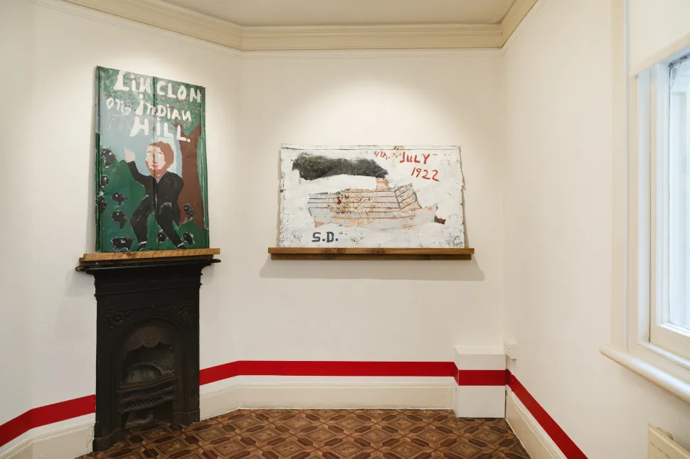 Two paintings by Sam Doyle depicting Abraham Lincoln at Indian Hill and a steamship marked “4th July 1922” are displayed above fireplaces at The Gallery of Everything.