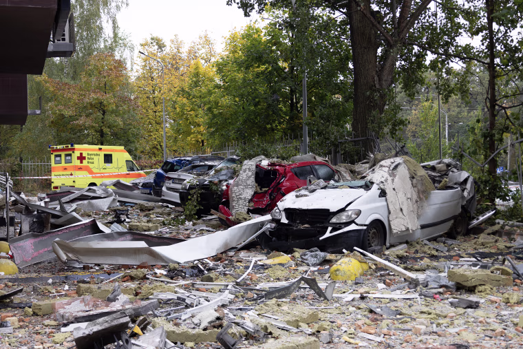 Pictured: A destroyed car in the rubble of a residential building courtyard.
