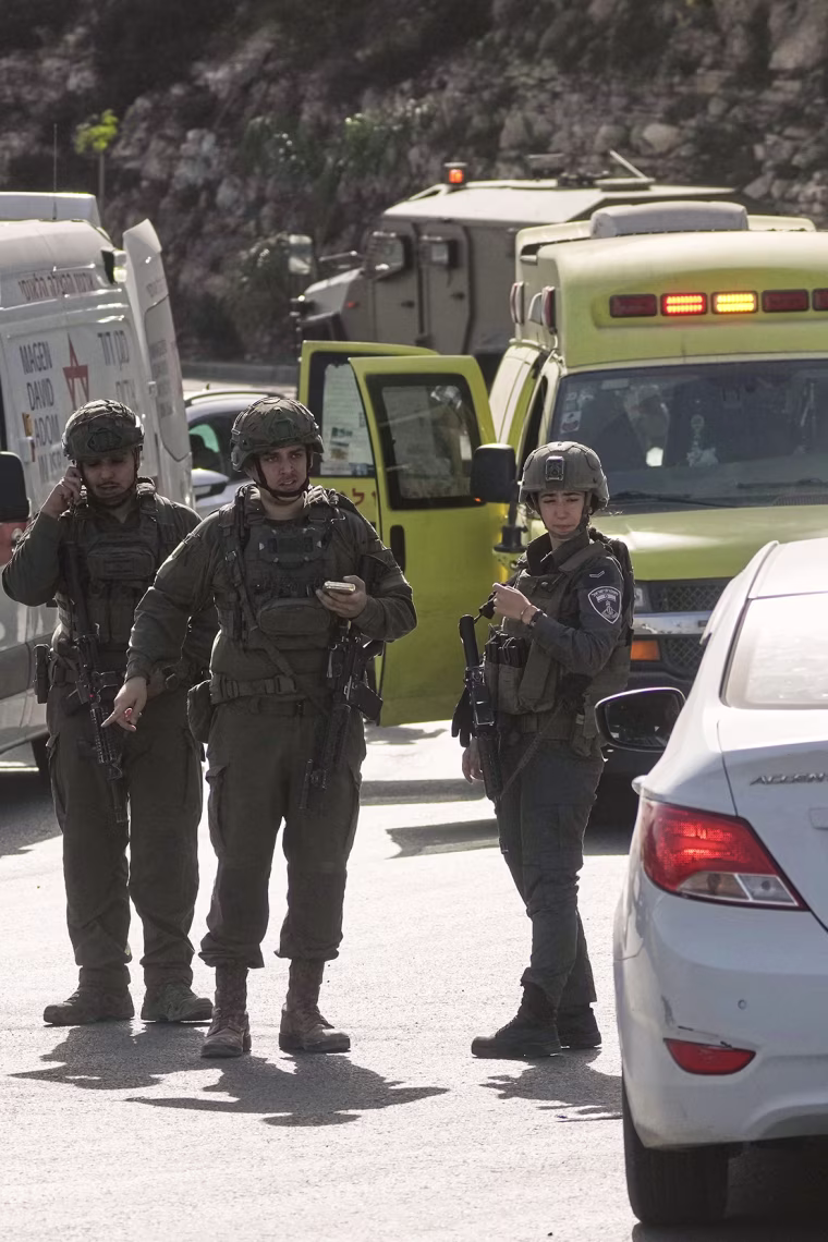 Pictured: Israeli soldiers and first responders gather near an ambulance