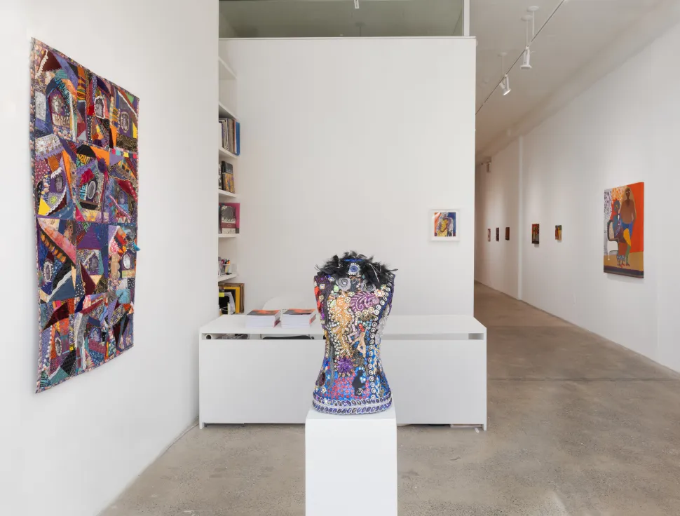 A mixed-media quilt by Dindga McCannon honoring African American suffragettes, composed of vividly patterned fabric, stitching, buttons, beads and archival portraits arranged in irregular patchwork sections.