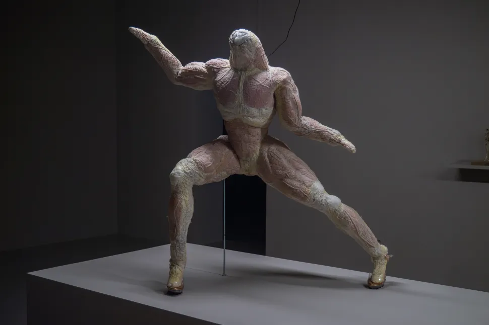 A human sculpture made of flesh in an athletic pose