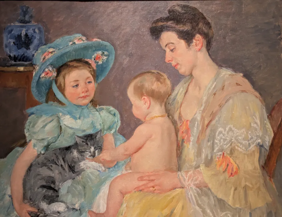 One painting shows a woman holding a baby who is reaching for a cat held by a little girl wearing a large hat.