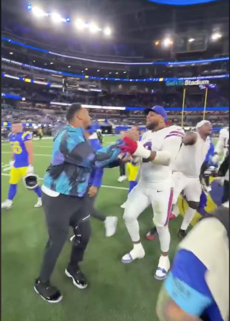 Odell Beckham Jr. celebrates with fans on the field after a football game.
