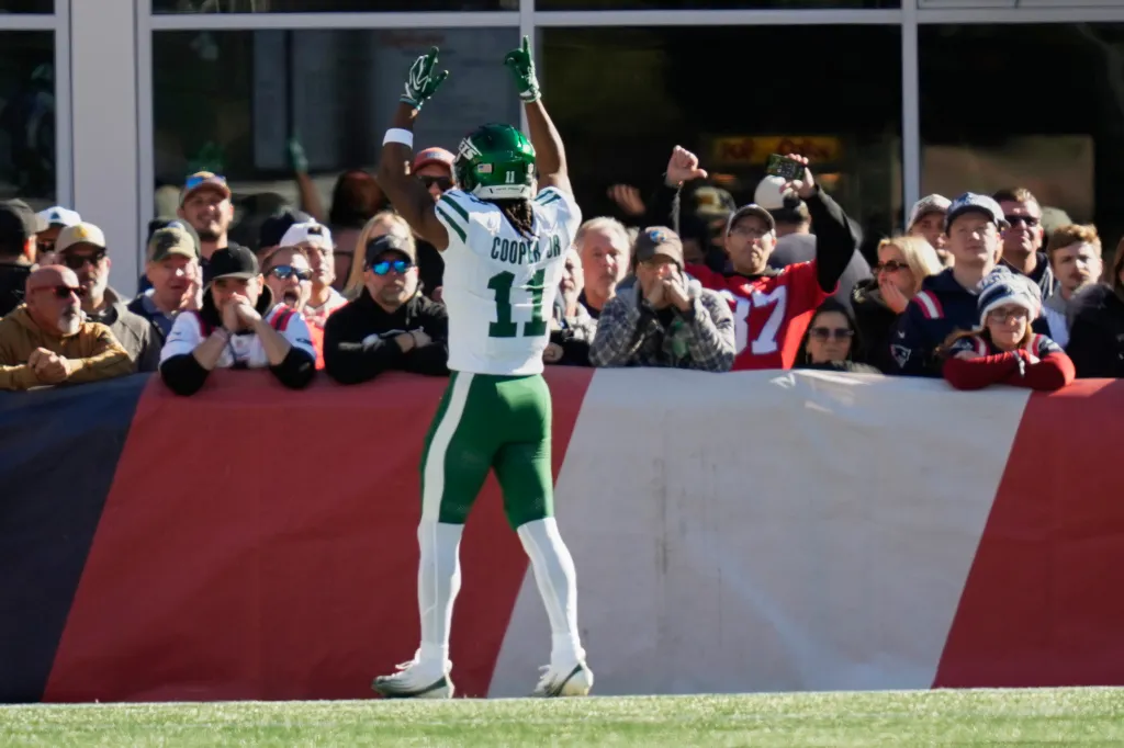 New York Jets wide receiver Omar Cooper Jr. celebrates a touchdown in front of New England Patriots fans.