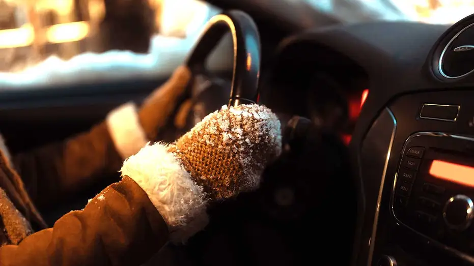 A gloved driver's hand on the wheel