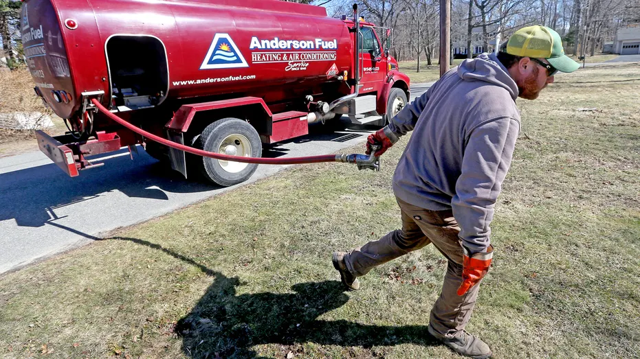 A man delivers heating oil to a house.