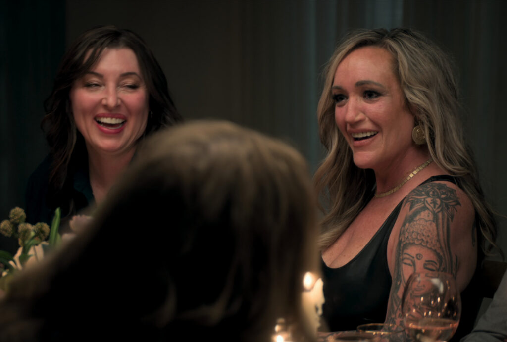 Two women sat at a candlelit dinner table and laughed.