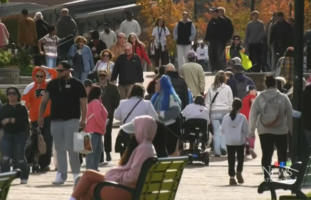 A large group of people walked along the boardwalk.